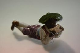 A 19th century majolica pottery figure of a recumbent negro boy eating melon, impressed marks to