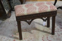 A 19th century carved oak dressing stool in the Gothic taste, the upholstered seat above a relief-