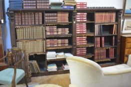 A Victorian scumbled and stained pine open bookcase, the overhanging cornice supported on scroll