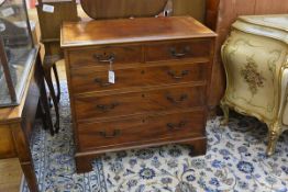 A small George III crossbanded mahogany chest of drawers, the moulded top above two short and