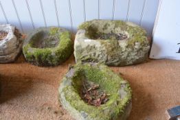 A group of three weathered stone small garden trough planters, one indistinctly carved with a