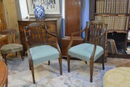 A pair of Edwardian Sheraton Revival painted mahogany open armchairs, each with arched crest rail