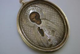 A Russian silver pendant icon, probably 18th century, oval, the silver cut back to reveal the