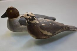 Two 19th/early 20th century painted wooden decoy ducks, each with glass eyes, one with metal ring to