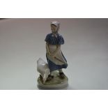 A Royal Copenhagen porcelain figure of a goose girl, model no. 527. 24cm