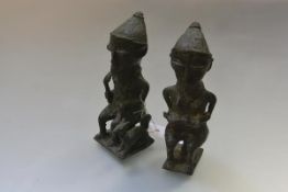 A pair of African bronze figures, probaby Yoruba, Nigeria, each seated, the man with fly whisk,