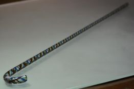 A glass cane of Nailsea type, with coloured overlay and airtwist decoration. Length 107cm