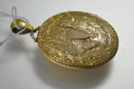 A large Victorian yellow metal (unmarked) locket, oval, engraved with ferns and foliage, enclosing