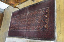 A Caucasian rug, the central panel with seven octagonal medallions enclosed within interlocking