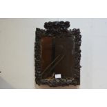 A carved oak picture frame, probably early 18th century, the crest with a cartouche flanked by