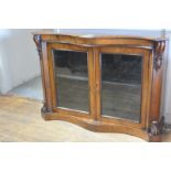 A mid-Victorian walnut side cabinet. c. 1860, the serpentine top with canted corners over a pair