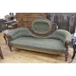 A mid-Victorian walnut framed sofa, the oval cartouche buttoned back within a foliate carved