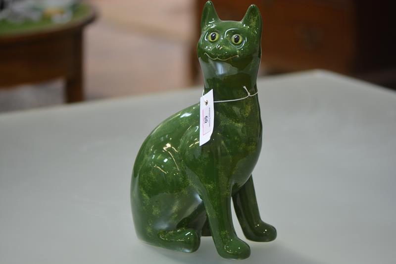 A Griselda Hill for Wemyss Pottery model of a seated cat, glazed in mottled green, with glass