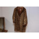 A 1940's leopard skin fur-trimmed three-quarter length coat, with fur shawl collar and cuffs.