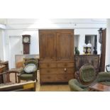 A George IV mahogany linen press, the moulded cornice above a pair of shaped fielded panel doors