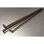Two walking sticks with rhino horn handles, the first an ebonised cane, with knop handle and
