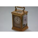 A French gilt-brass repeating carriage clock, c. 1900, the white enamel dial with Roman numerals and