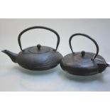 Two Japanese iron kettles or teapots, Meiji period, each of compressed spherical form and