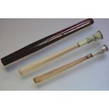 Two early 20th century ivory and engine turned enamel cigarette holders, one with ribbon tied floral