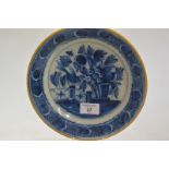 A Dutch Delft plate, 18th century, the well decorated with a bird on a fence within a border of
