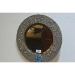 A polished pewter mirror in the Art Nouveau taste, c. 1900, circular, enclosing a bevelled plate,