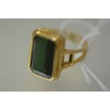 A green tourmaline dress ring the large rectangular-cut stone set within a stepped band on split