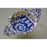 A tin-glazed earthenware porringer, in the style of Delft, moulded and painted in blue with a basket