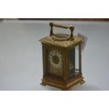 A French gilt-brass repeating carriage clock, c. 1900, the gilt face decorated in relief with