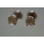 A pair of diamond ear studs, each brilliant-cut stone weighing approximately 0.4 carats, claw-set in