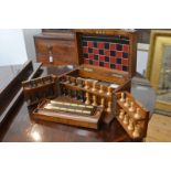 A late Victorian oak cased games compendium, the plain rectangular box opening to a cribbage board