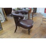 A 19th century buttoned leather open armchair, of horseshoe shape, with stuffed over seat and raised