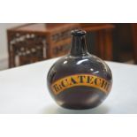 A large amethyst glass pharmacy bottle, 19th century, bearing a painted label "Tr: Catechu" (