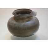 An Indian bronze pot, 19th century, of compressed spherical form, engraved with linear bands.