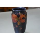A Moorcroft pottery vase, in the Pomegranate pattern against a blue ground, with everted rim and
