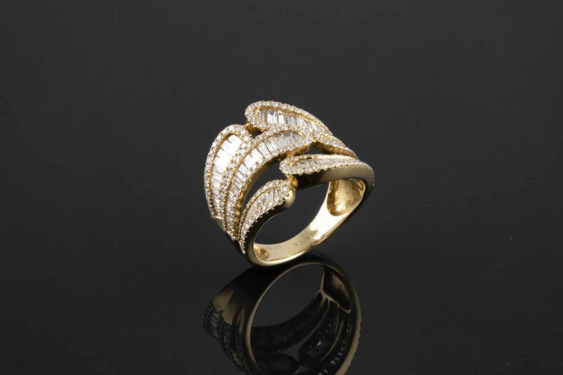 SORTIJA Realizada en oro, con motivos centrales de formas sinuosas, compuestas por diamantes talla