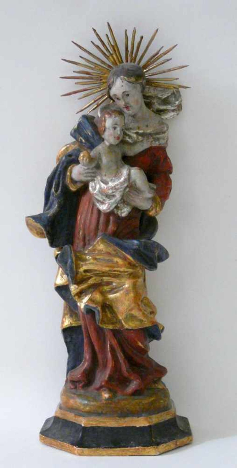 Madonna mit KindHolz, geschnitzt, farbig und gold gefasst, 18. Jahrhundert. Auf gekehltem Sockel und