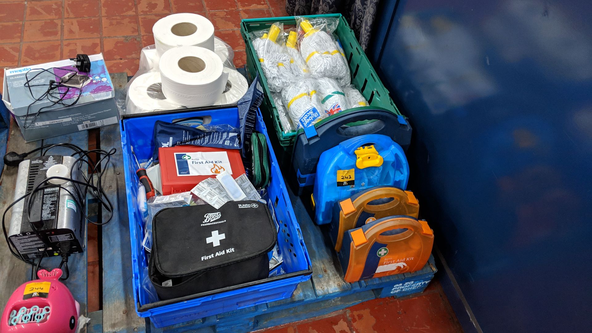 Double row of first aid equipment & cleaning consumables e.g. mop heads & rolls of toilet tissue