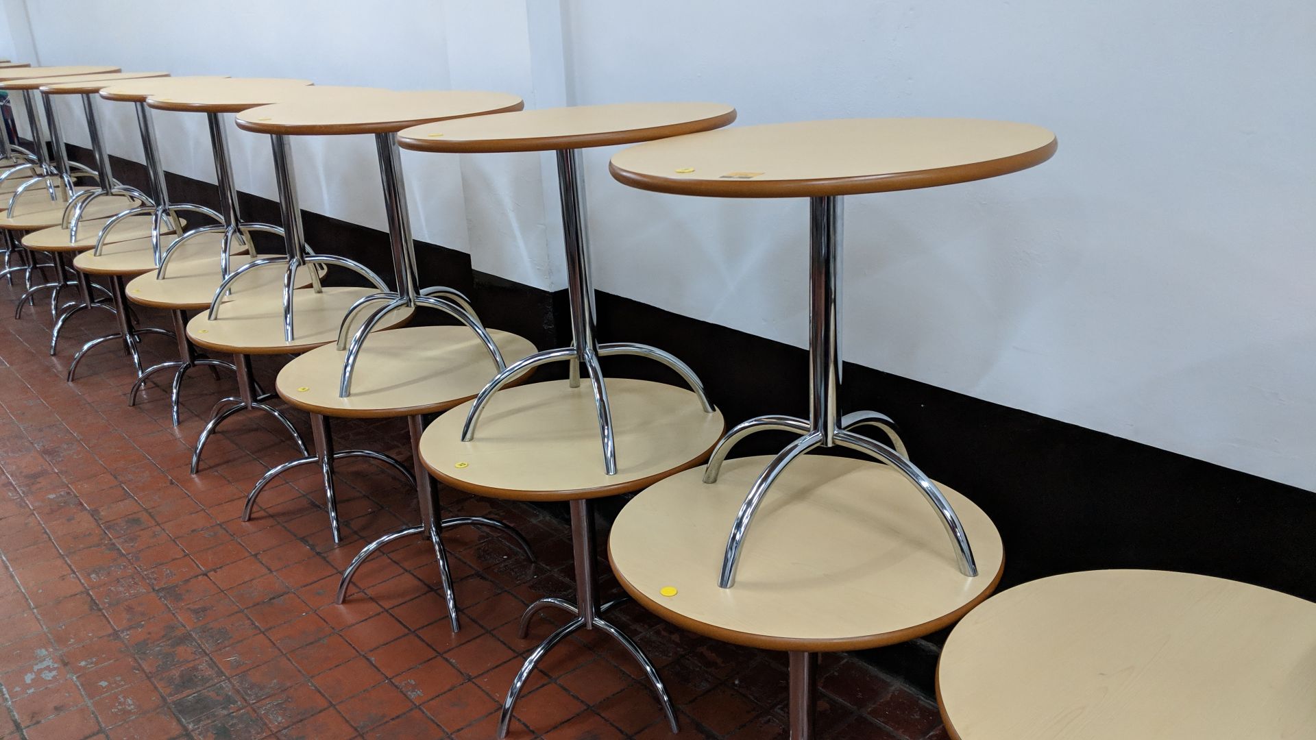 10 off café tables consisting of round tops on single pedestal 4-leg silver metal bases NB. Lots 173