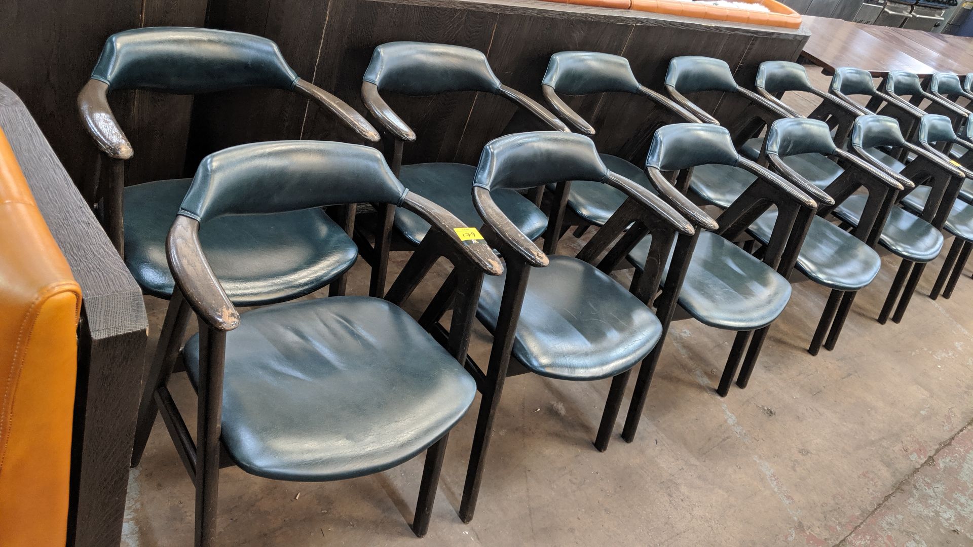 10 off upholstered wooden dining chairs with arms in a dark teal leather/leather type covering. NB