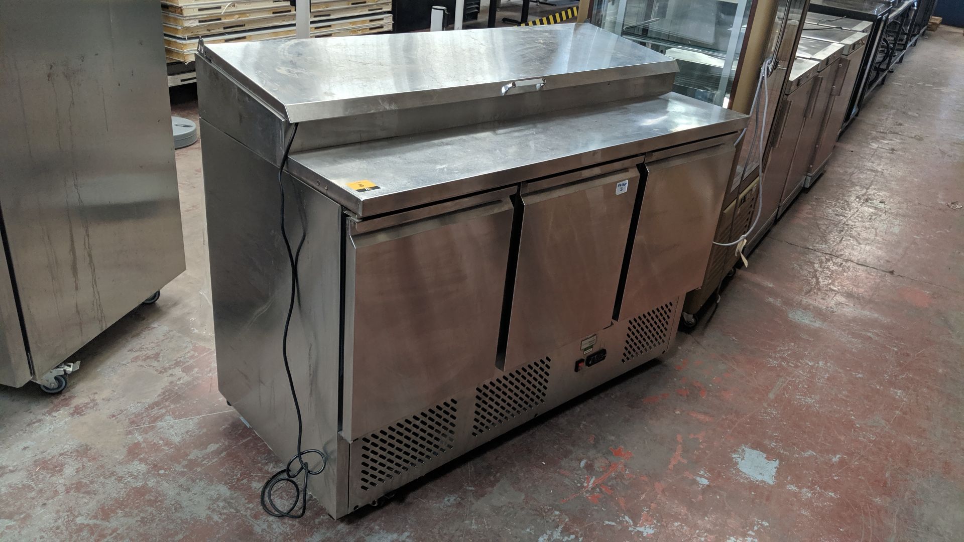 Interlevin stainless steel refrigerated triple door prep counter with hinged lid access salad