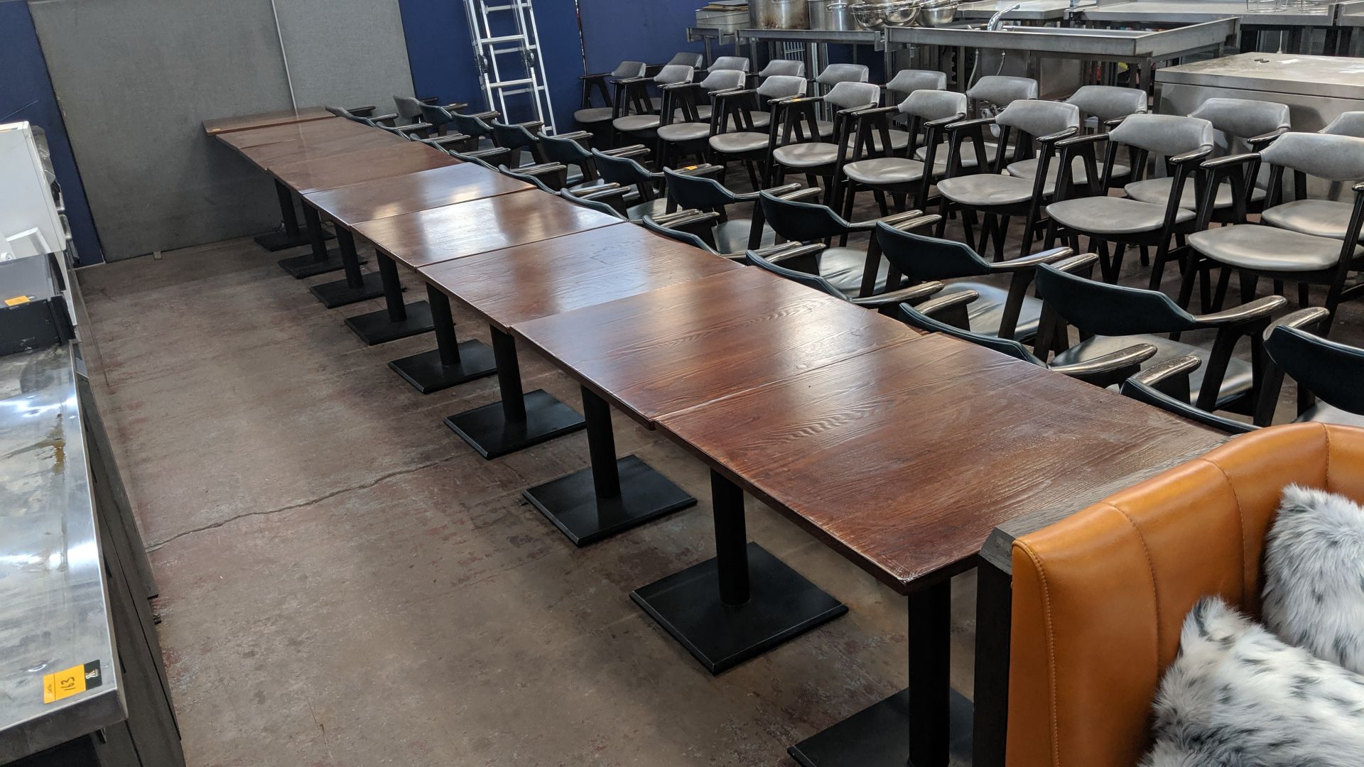 9 off matching square wooden dining tables on single pedestal bases, each with a table top measuring