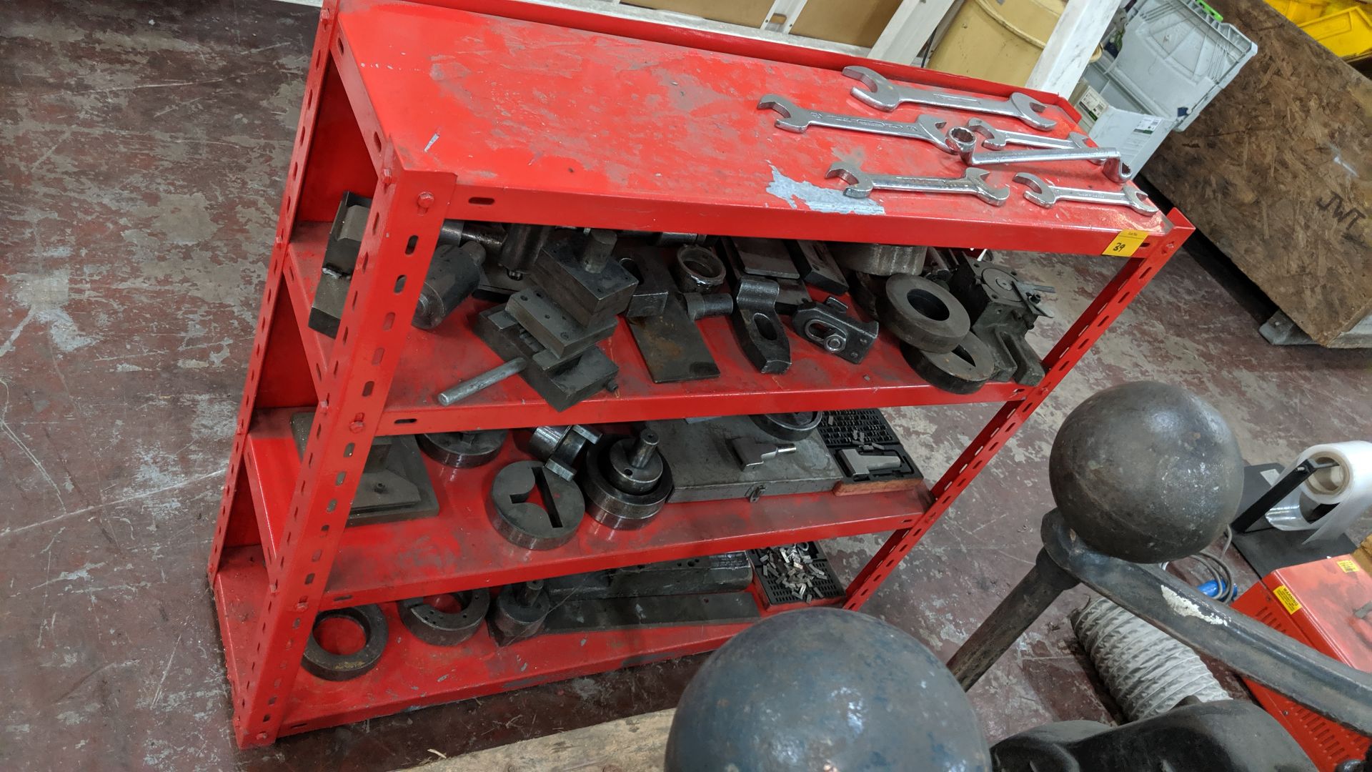 Quantity of tooling for use with fly presses, including the red shelving unit upon which the tooling