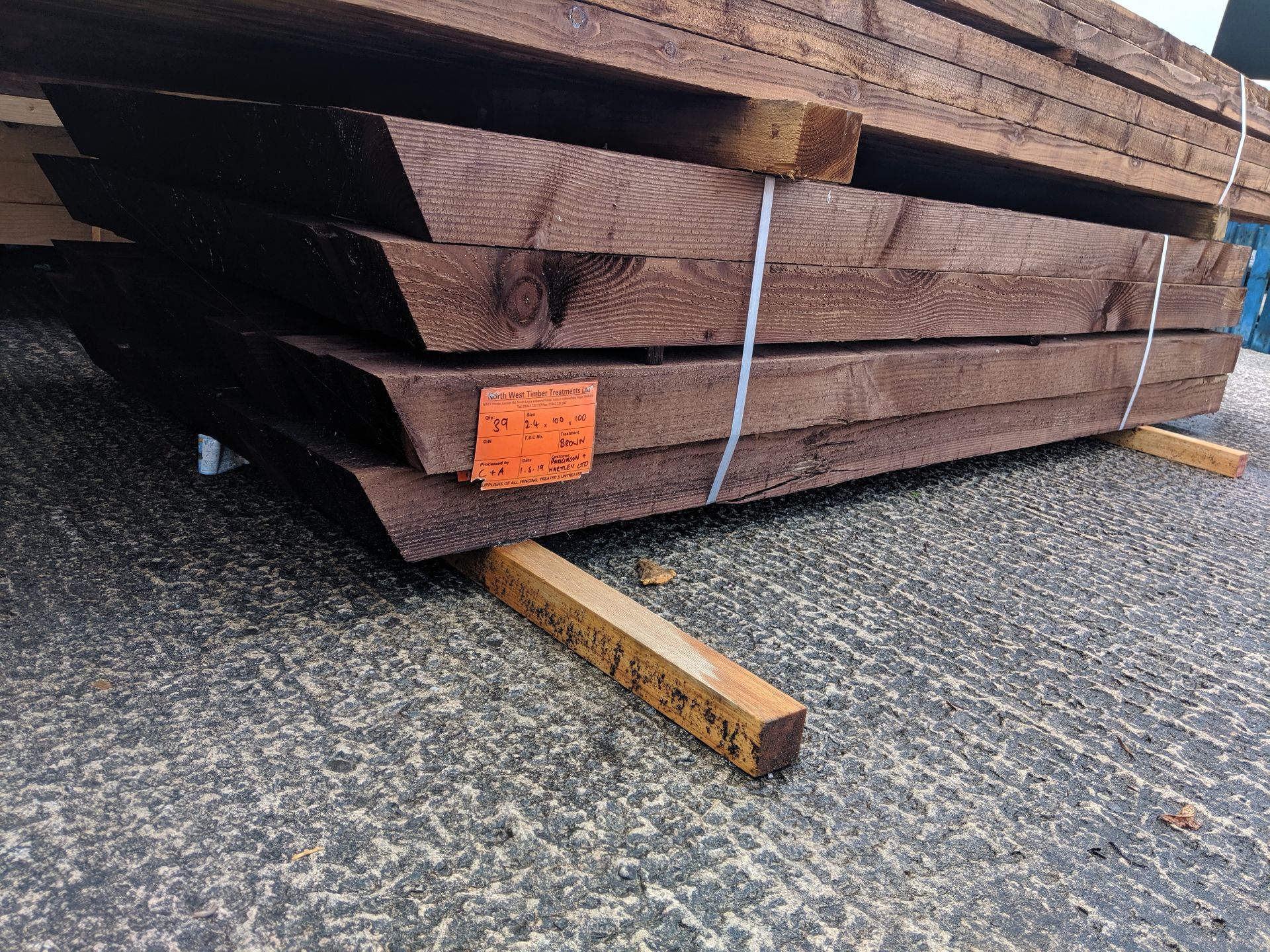 Bundle containing approximately 39 brown treated fence posts, indicated on a label as being size 2.4 - Image 2 of 5
