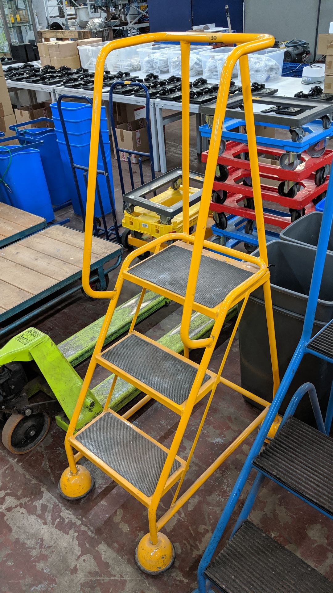 Yellow mobile metal access/mini library steps. This is one of a large number of lots being sold on