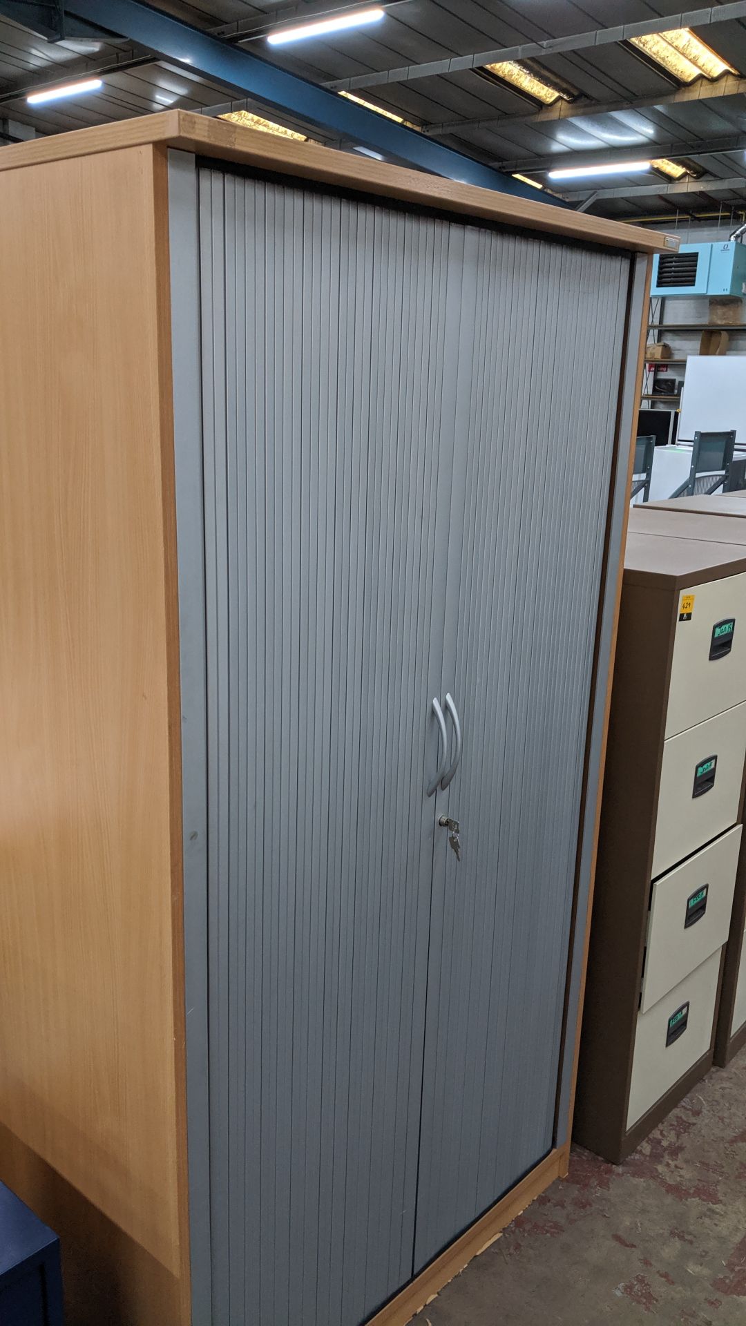 Tambour-front tall stationery cupboard with key. This is one of a large number of lots used/owned by