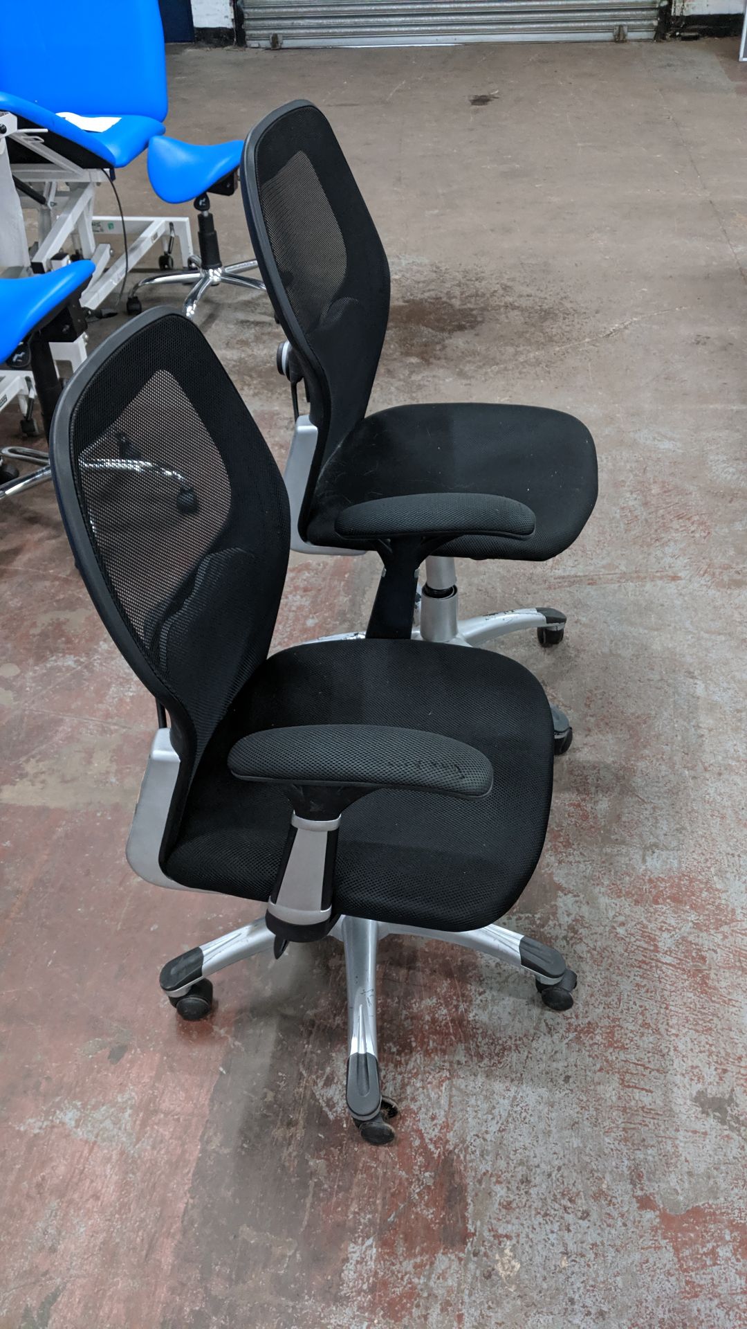 Pair of modern silver & black mesh back operator's chairs, one with arms & one without. This is