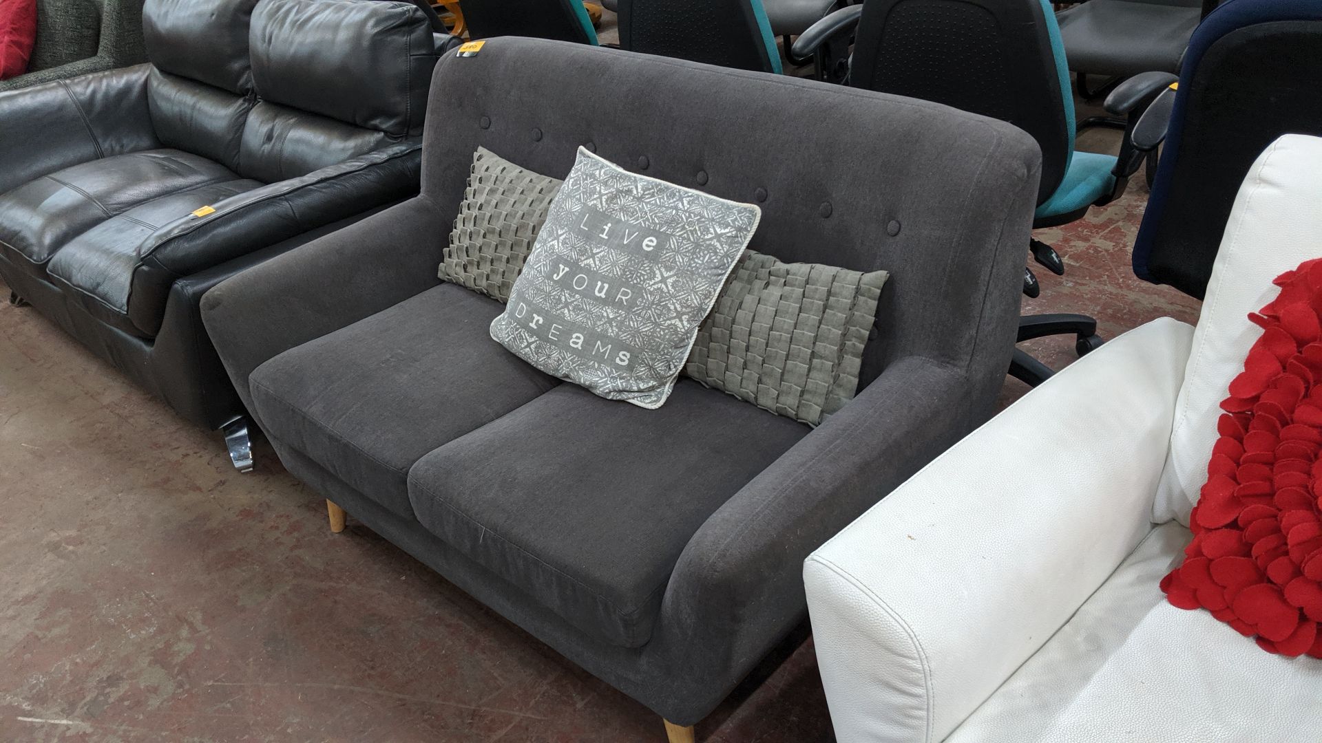 Grey sofa on wooden legs with 3 assorted cushions. This is one of a large number of lots used/