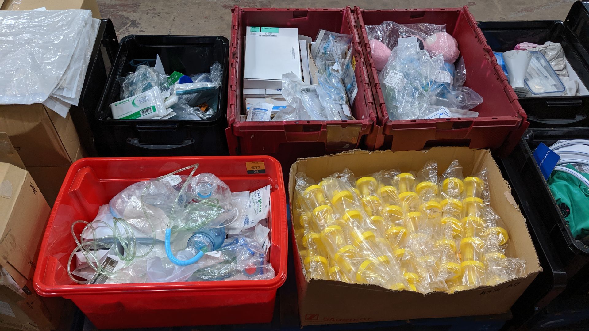 Contents of a pallet of assorted medical supplies including single use resuscitators, beakers,