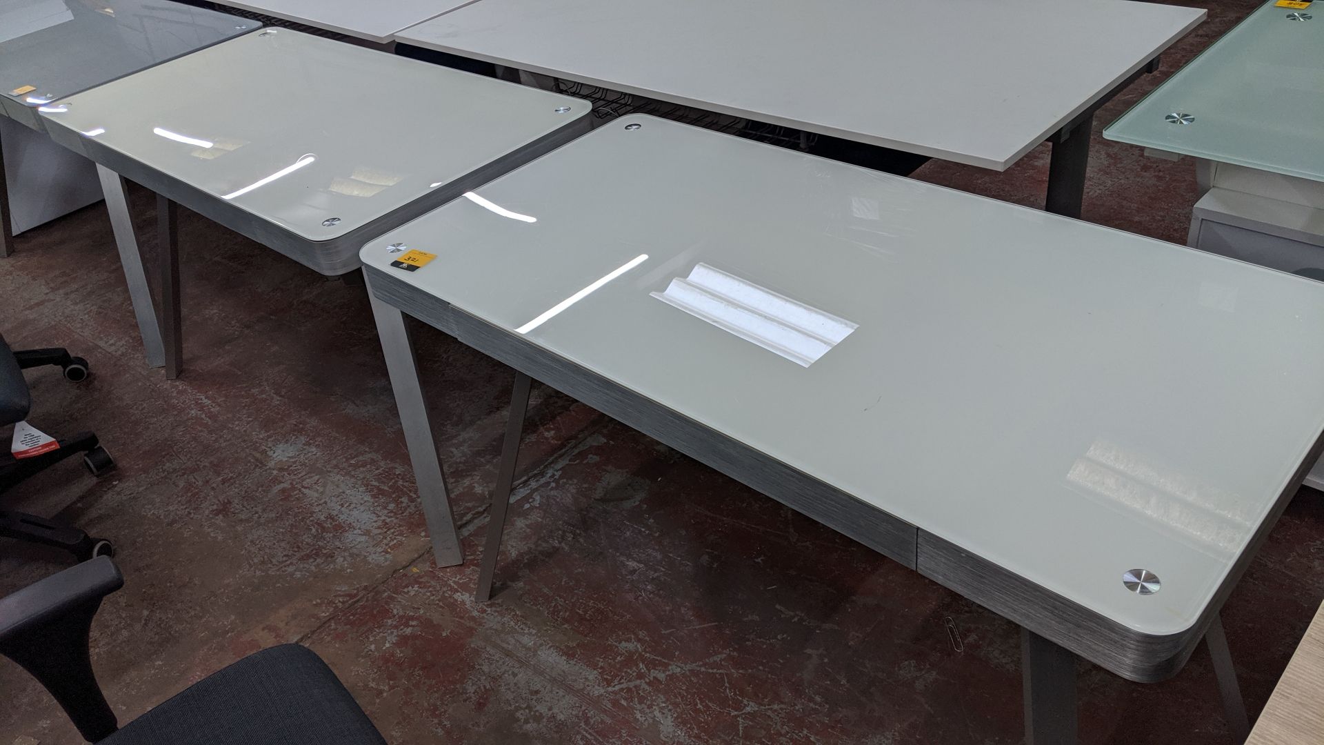 Pair of matching modern glass & silver metal desks. This is one of a large number of lots used/owned