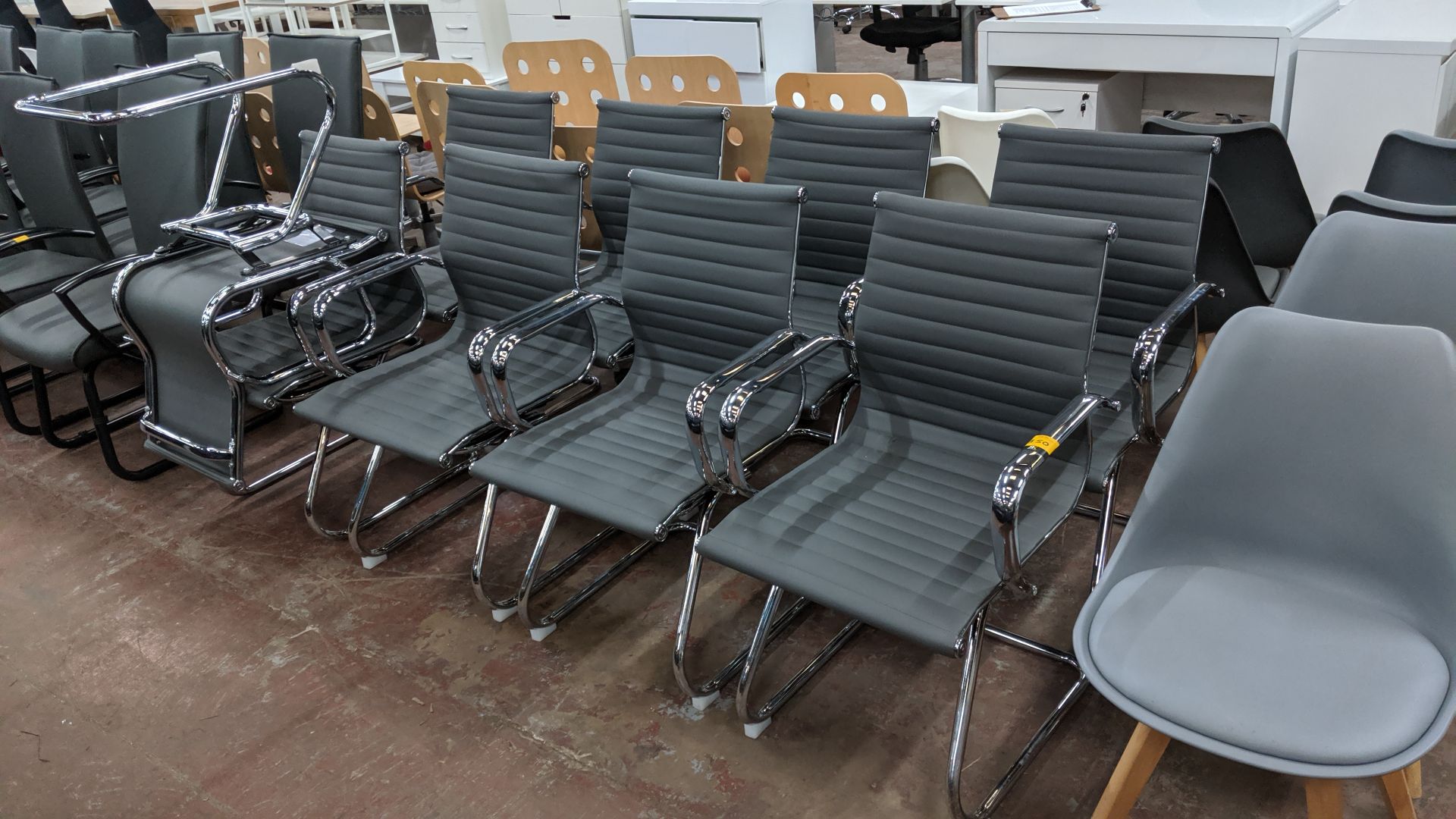 9 off matching chrome cantilever framed chairs with grey ribbed fabric upholstery. This is one of